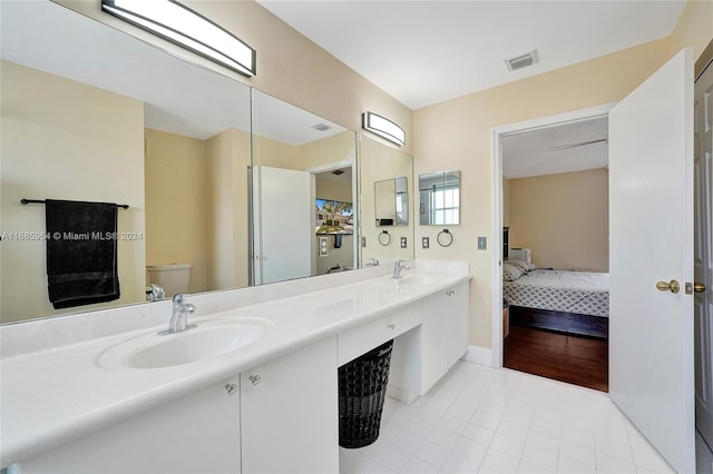 bathroom with toilet, vanity, and wood-type flooring