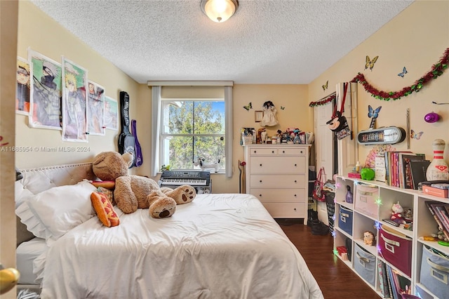 bedroom with a textured ceiling and dark wood-type flooring