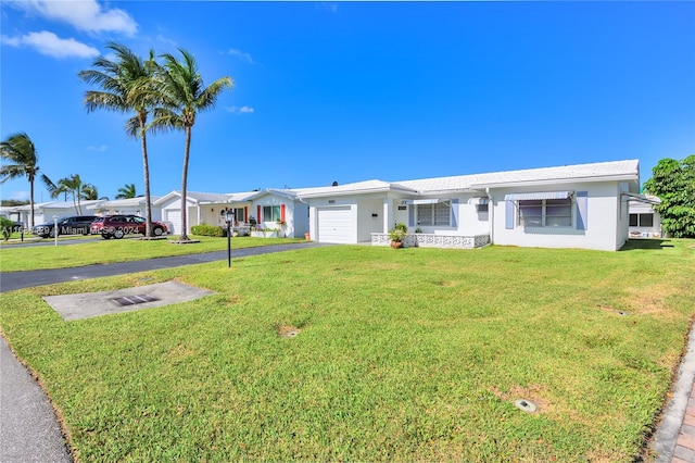 single story home featuring a front lawn and a garage