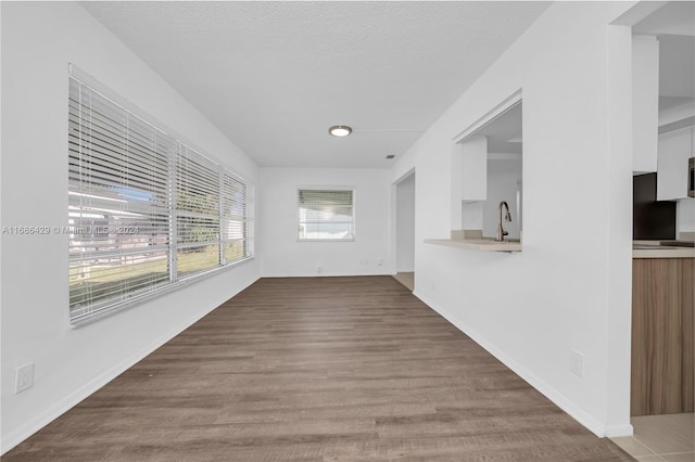 2851 W Golf Blvd, Pompano Beach, FL 33064 - unfurnished living room featuring a sink, wood finished floors, a textured ceiling, and baseboards