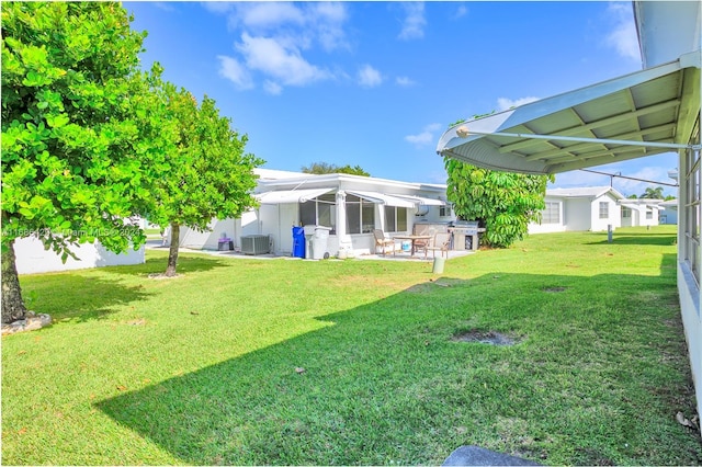 2851 W Golf Blvd, Pompano Beach, FL 33064 - view of grassy yard with central AC and a patio