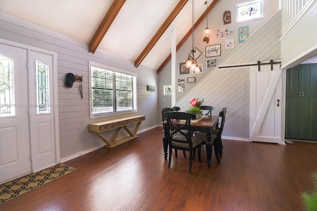 dining room with beamed ceiling, dark wood-type flooring, a barn door, high vaulted ceiling, and wood walls