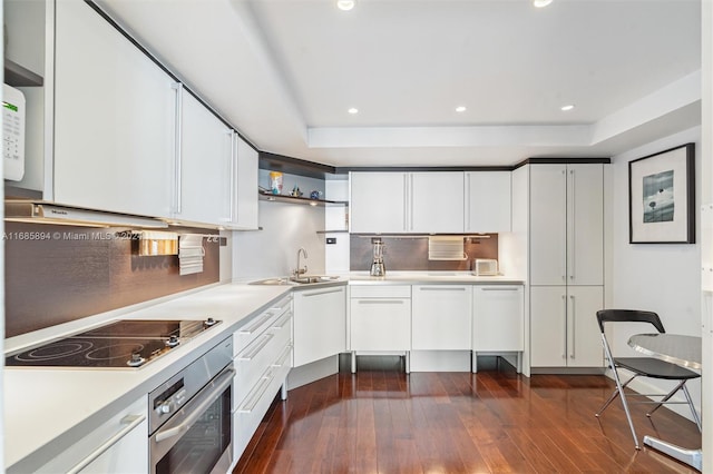 kitchen featuring white cabinetry, black electric stovetop, oven, and dark wood-type flooring