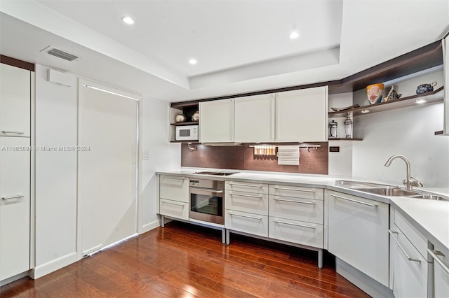 kitchen with sink, stainless steel oven, and white cabinets