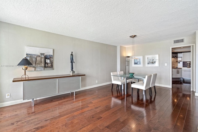 dining room with dark hardwood / wood-style floors and a textured ceiling