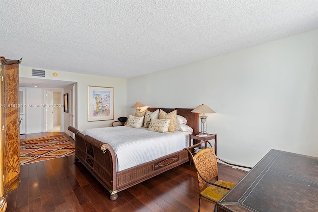 bedroom with dark wood-type flooring and a textured ceiling