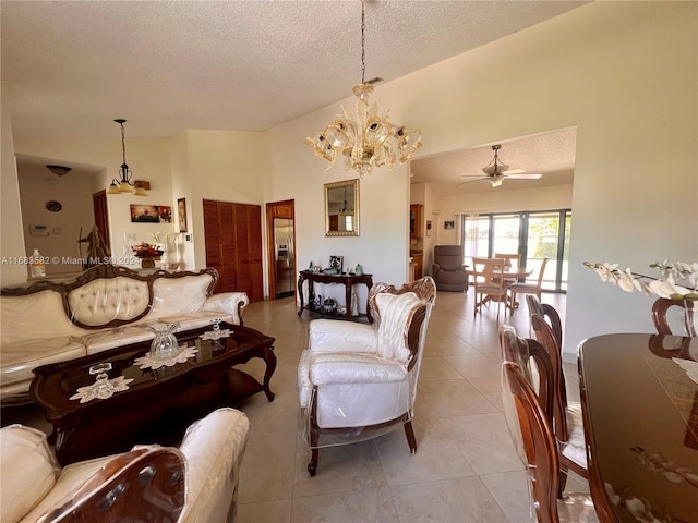 tiled living room featuring a textured ceiling and ceiling fan with notable chandelier