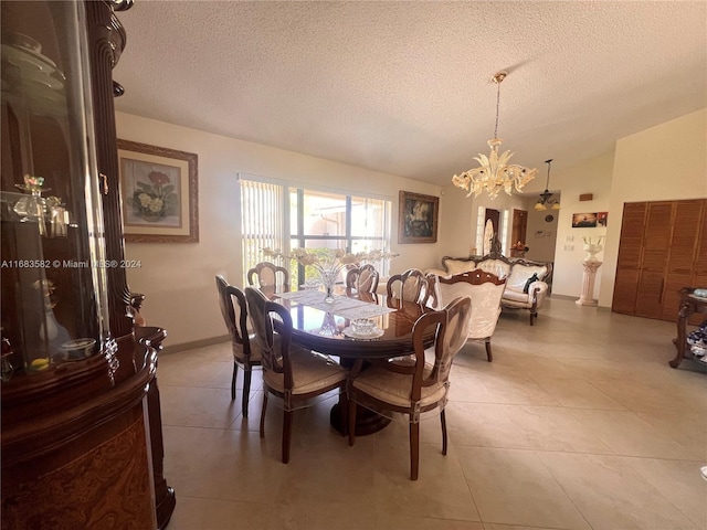 dining area with a notable chandelier, a textured ceiling, lofted ceiling, and tile patterned flooring