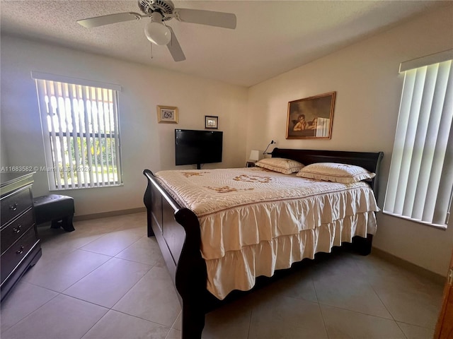 tiled bedroom featuring ceiling fan and a textured ceiling