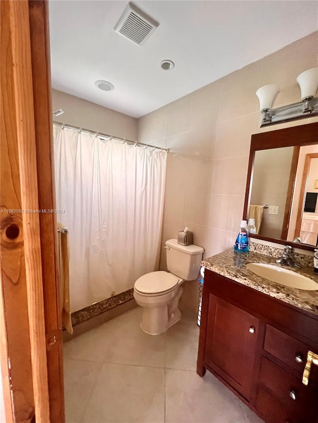 bathroom featuring tile walls, vanity, a shower with shower curtain, and toilet