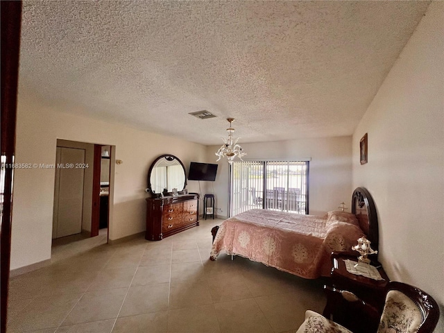 bedroom with light tile patterned flooring, a textured ceiling, and an inviting chandelier