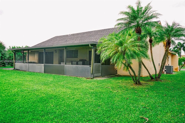 back of property with a yard, a sunroom, and central air condition unit