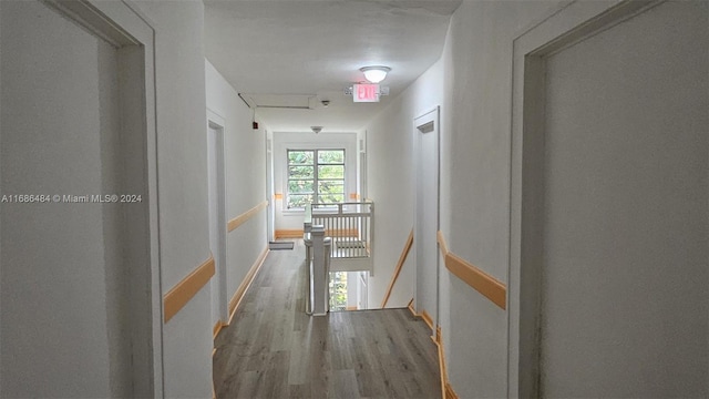 corridor with hardwood / wood-style flooring