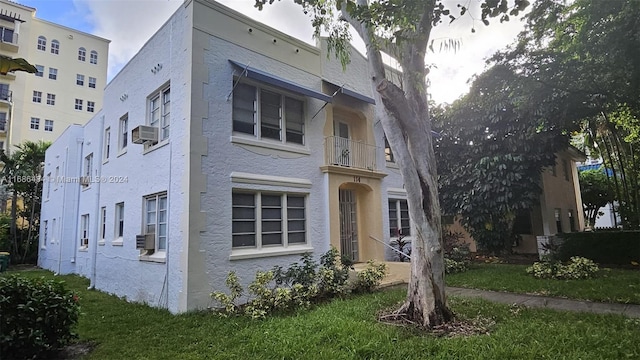 view of front facade with cooling unit, a front yard, and a balcony