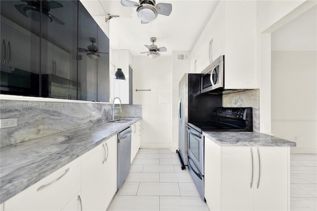 kitchen featuring decorative backsplash, appliances with stainless steel finishes, sink, light tile patterned floors, and white cabinets