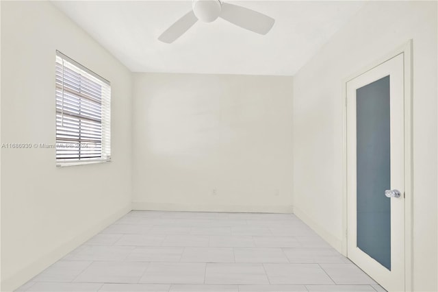 spare room featuring light tile patterned floors and ceiling fan