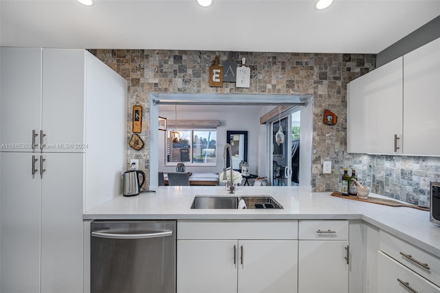 kitchen featuring dishwasher, white cabinets, sink, and backsplash