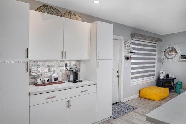 kitchen with decorative backsplash, light hardwood / wood-style flooring, and white cabinetry