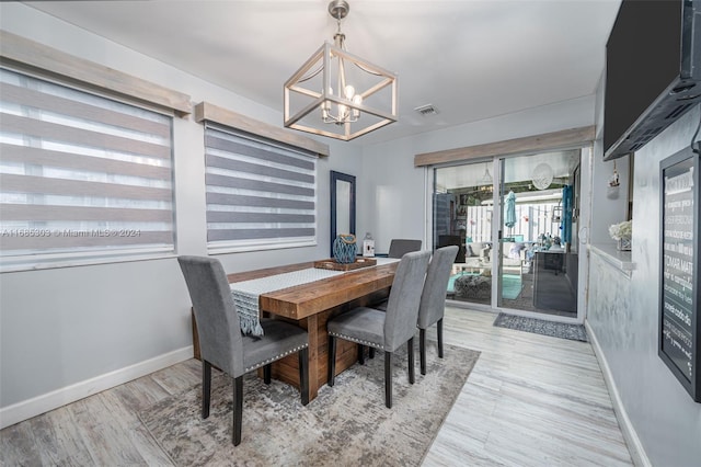 dining area featuring light hardwood / wood-style flooring and a chandelier