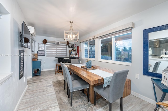 dining area with a notable chandelier and light hardwood / wood-style floors