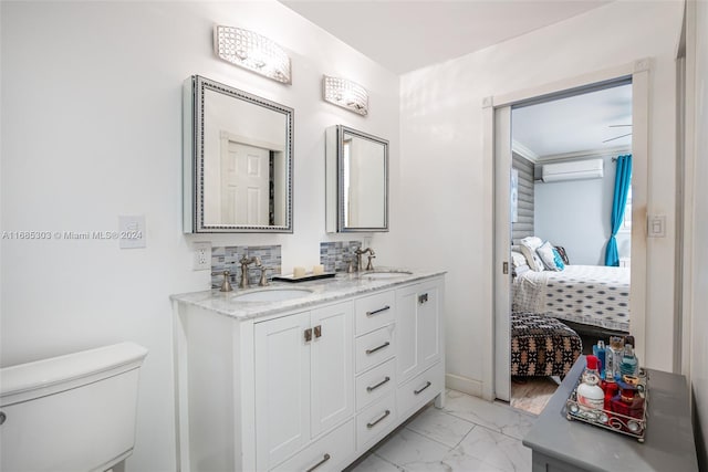 bathroom with an AC wall unit, vanity, and toilet