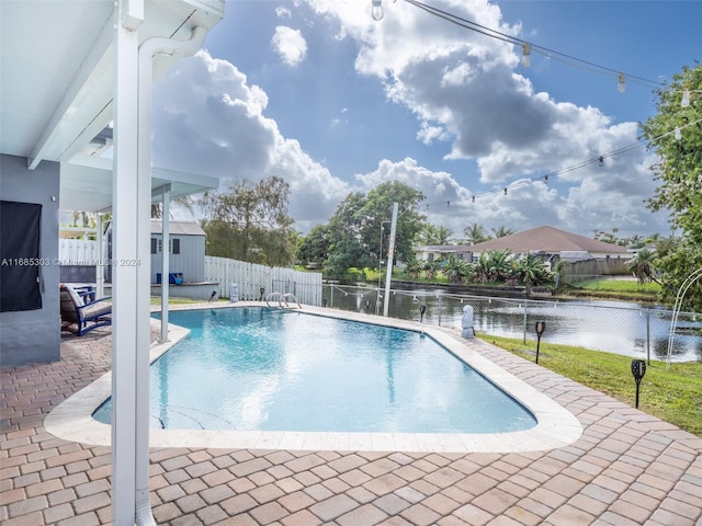 view of pool with a water view and a patio