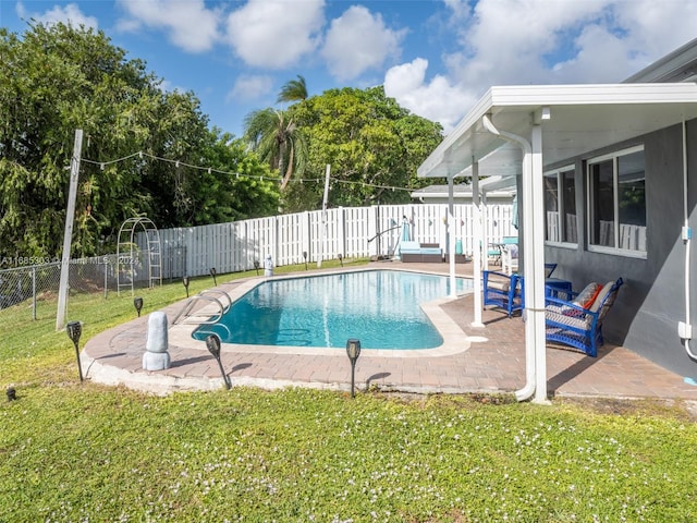 view of pool featuring a patio and a yard