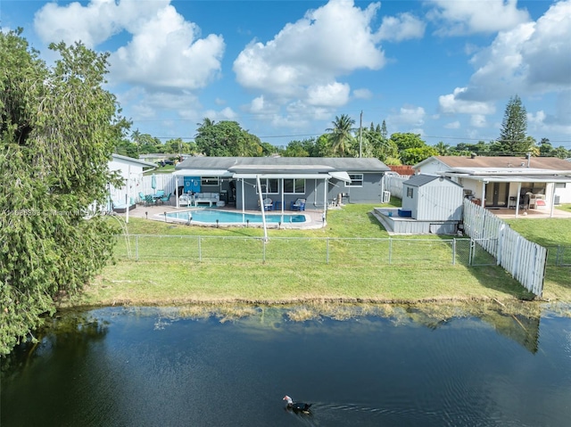 rear view of property with a water view, a patio area, a fenced in pool, and a yard