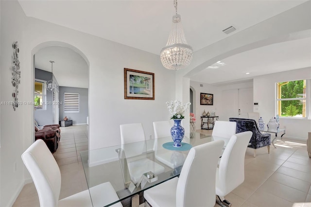 dining space with light tile patterned floors and a notable chandelier