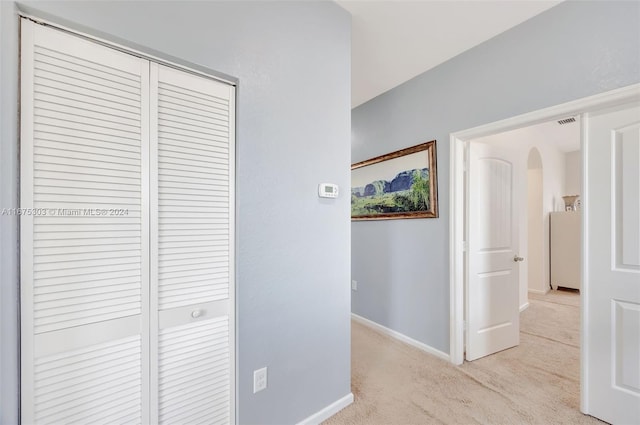 hall with light colored carpet