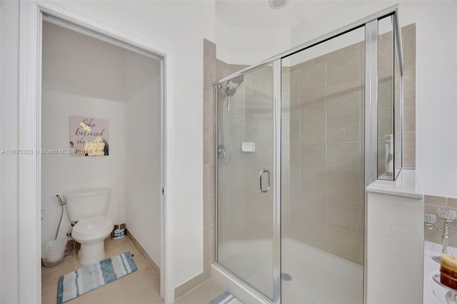 bathroom with tile patterned flooring, toilet, and a shower with shower door