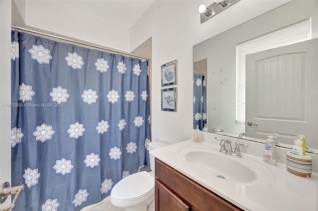 bathroom featuring a shower with shower curtain, vanity, and toilet