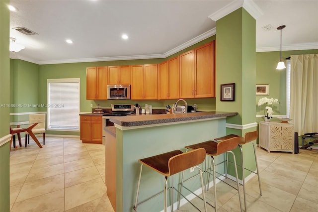 kitchen featuring kitchen peninsula, a breakfast bar area, ornamental molding, decorative light fixtures, and stainless steel appliances