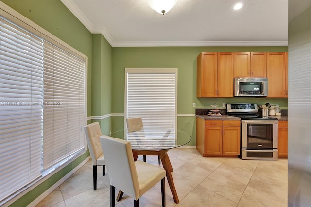 kitchen with crown molding, a healthy amount of sunlight, stainless steel appliances, and light tile patterned floors