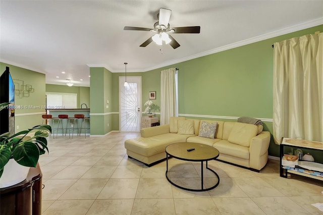 living room featuring ornamental molding, light tile patterned floors, and ceiling fan