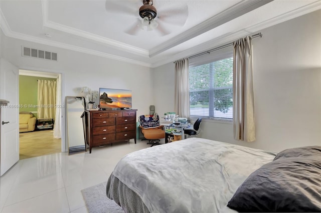 tiled bedroom with ceiling fan, a raised ceiling, and ornamental molding