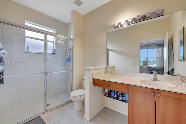 bathroom with vanity, toilet, tile patterned flooring, and a shower with door