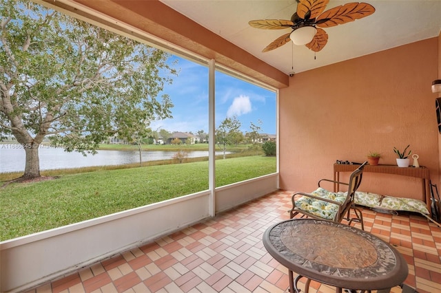 sunroom featuring a water view and ceiling fan