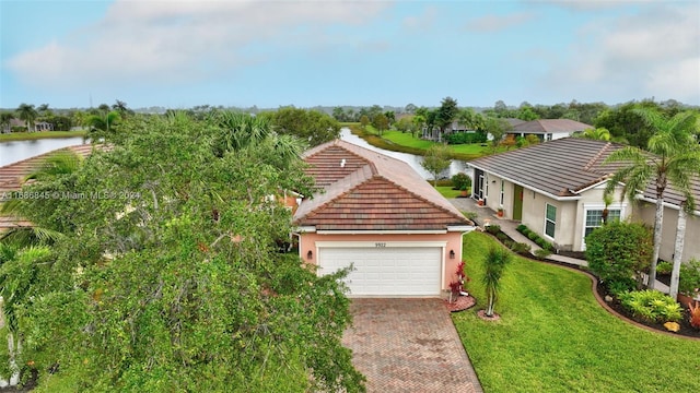 view of front of home featuring a front yard, a garage, and a water view