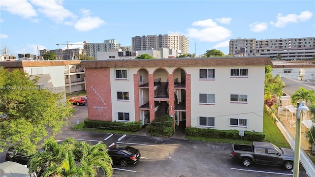 view of property with uncovered parking and a city view