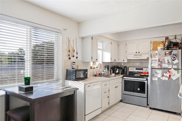 kitchen featuring stainless steel appliances, backsplash, a sink, and under cabinet range hood