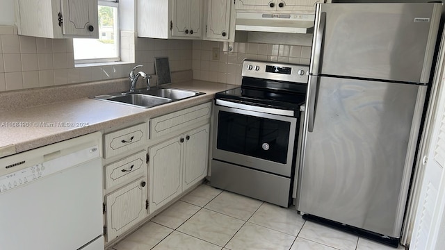 kitchen with stainless steel appliances, light countertops, a sink, and under cabinet range hood