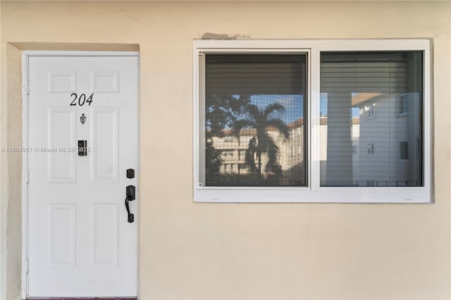 property entrance with stucco siding