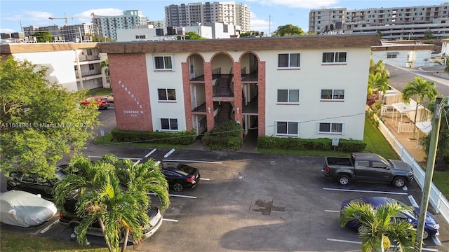 view of building exterior featuring uncovered parking and a city view