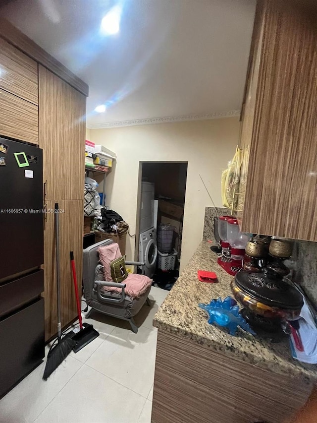 interior space featuring stacked washing maching and dryer and light tile patterned floors