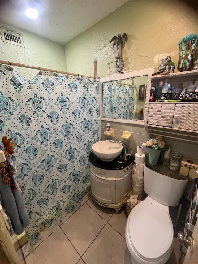 bathroom featuring toilet, tile patterned flooring, vanity, a shower with shower curtain, and tile walls