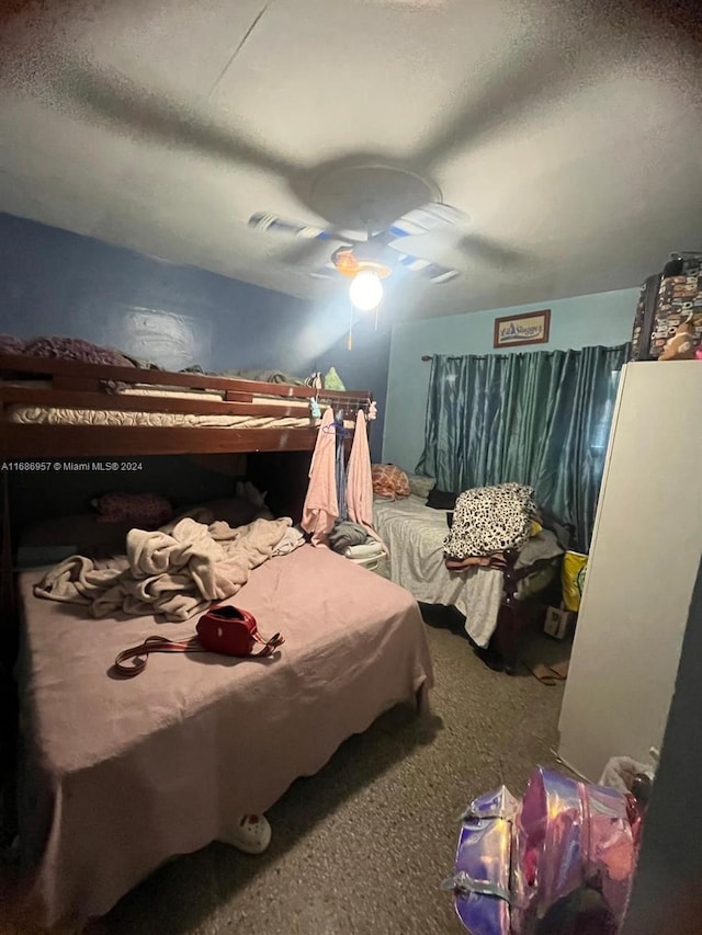 bedroom with a textured ceiling, carpet flooring, and ceiling fan