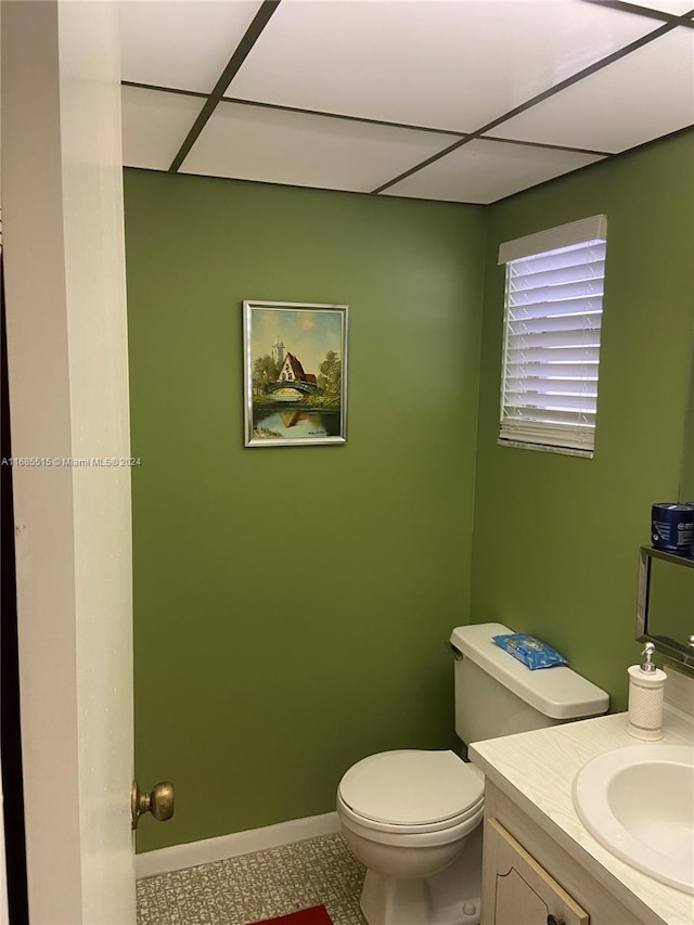 bathroom featuring vanity, a paneled ceiling, toilet, and tile patterned floors