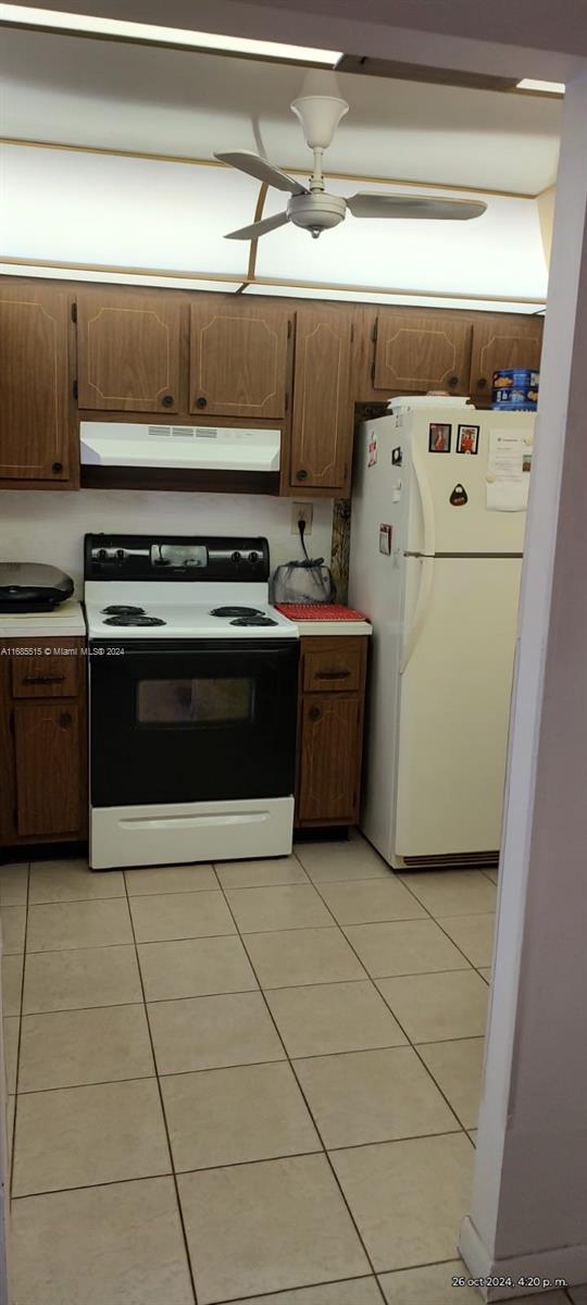 kitchen with ceiling fan, white appliances, and light tile patterned floors