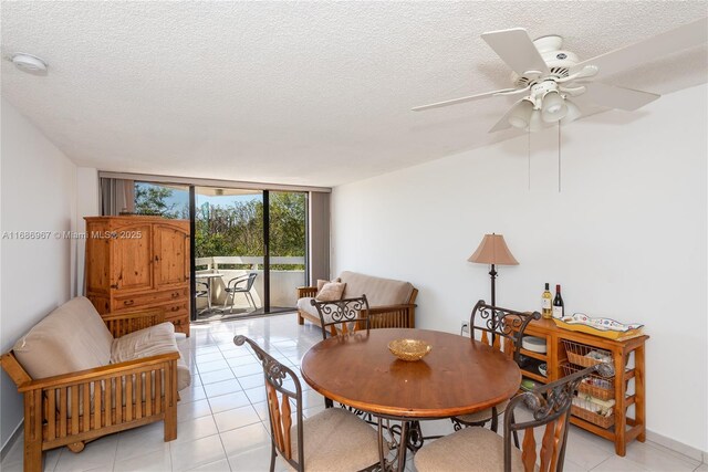 dining room featuring a wall of windows, a textured ceiling, and light tile patterned floors